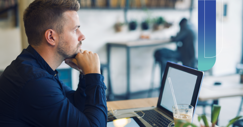 Founder reflecting on strategy while working on a laptop, deciding on the best virtual assistant systems for founders.